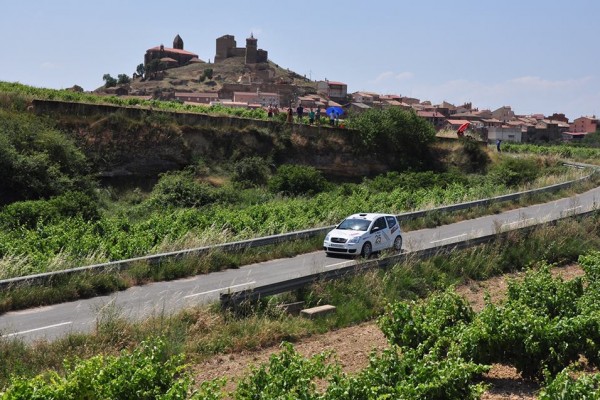 Coche de rally blanco al fondo el castillo de San Vicente de la Sonsierra