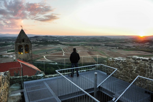 Un mombre observa el campanario de la Iglesia desde el Mirador de la Torre Mayor